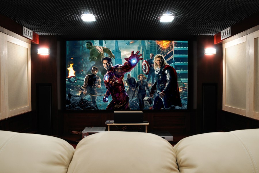 Home theater displaying the Avengers on the large screen in front of a comfortable couch.