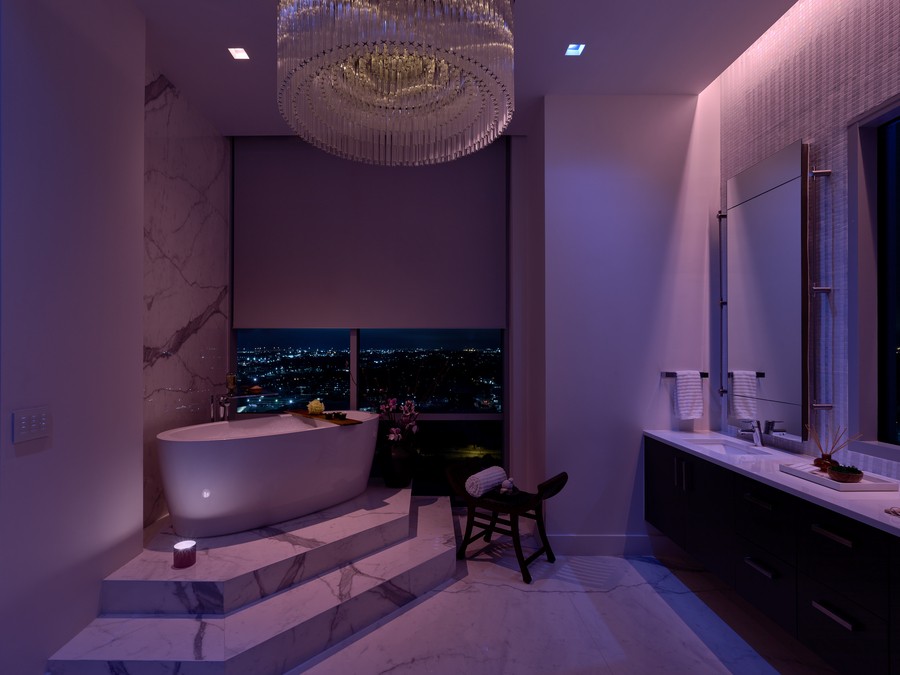 A bathroom with a soaking tub illuminated in Ketra’s violet LED lighting.