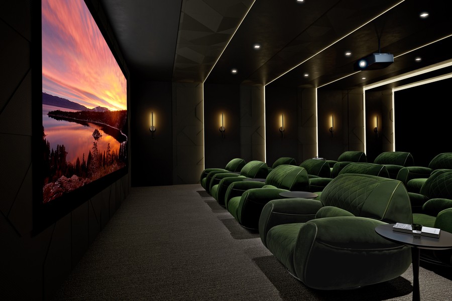 a home theater with green sofas and a projector 