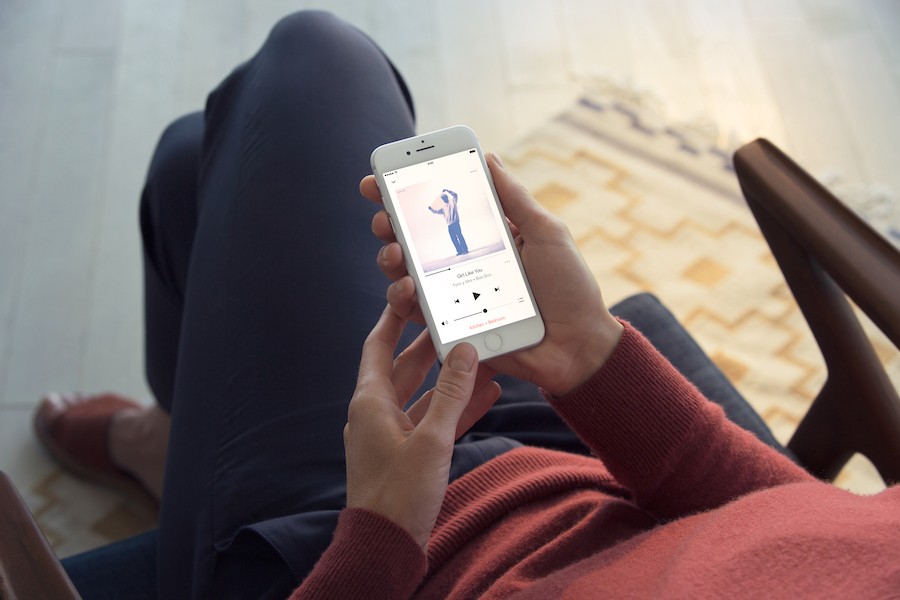 Woman changes her playlist using a whole-home audio app.