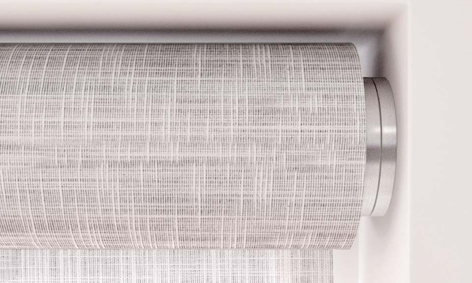 Close‑up of a textured light gray roller shade with a metallic recessed mounting bracket.